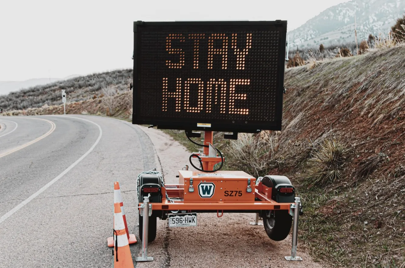 Sign on highway saying "Stay Home" 